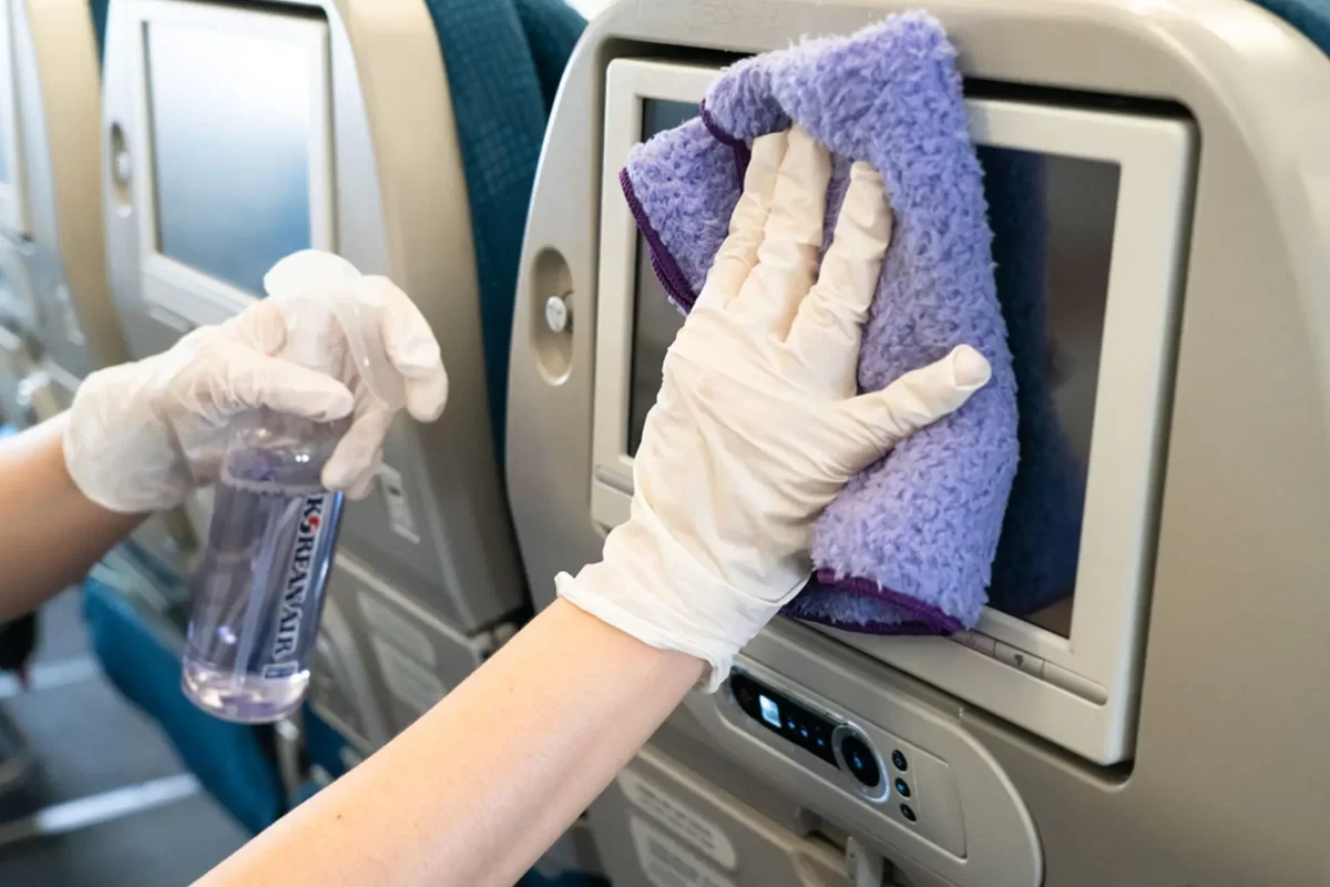 a hand in rubber gloves cleaning a purple towel